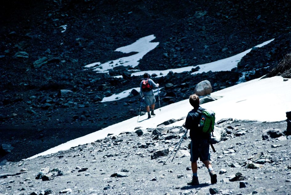 Persona practicando trekking con el paisaje del Cajón del Maipo de fondo.